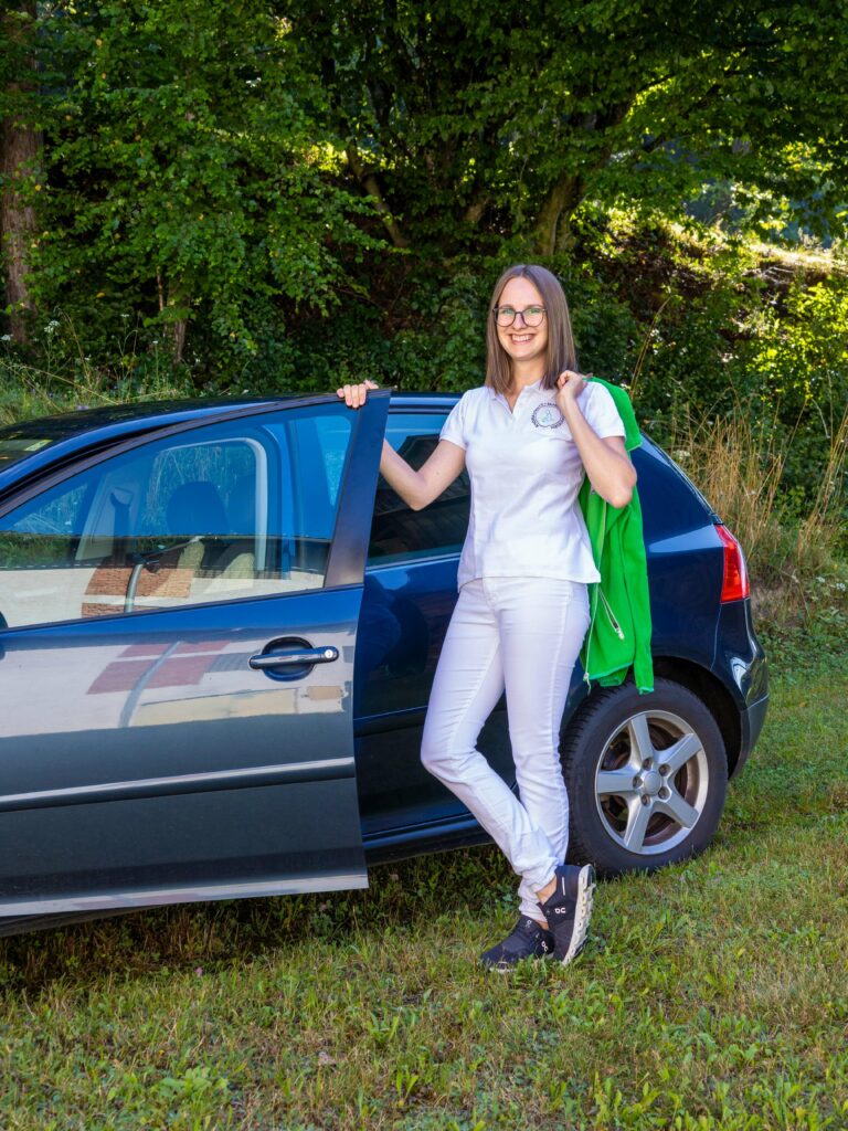 Portrait von Andrea Strutz vor ihrem Auto